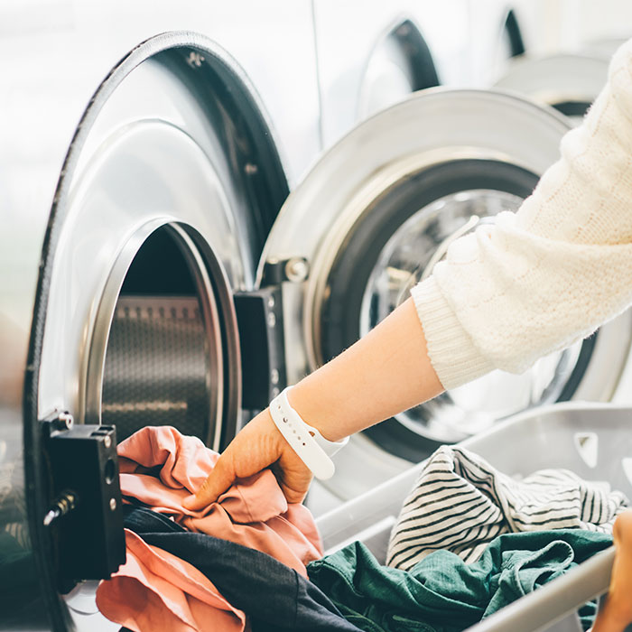 Woman pulling laundry out of a dyer