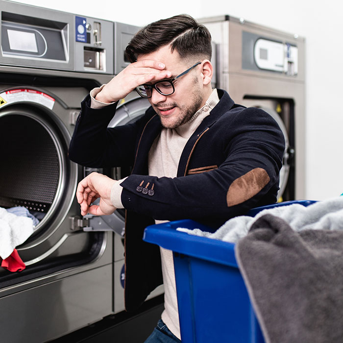 Man looking at his watch in a laundry matt